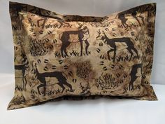 a decorative pillow with deers and trees on it