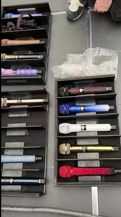 several different types of makeup are on display in black boxes with clear dividers to keep them organized