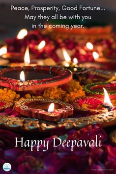 happy deepavali greeting card with candles and flowers on the ground in front of it