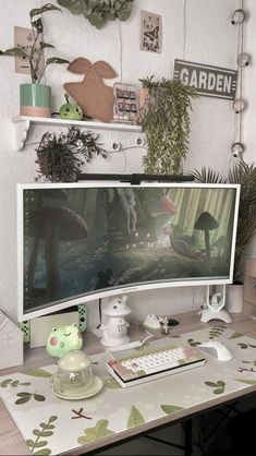 a computer monitor sitting on top of a desk next to a keyboard and mouse in front of a plant