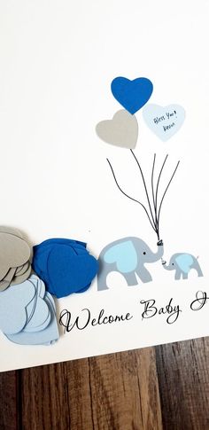 a welcome baby card with elephants and balloons