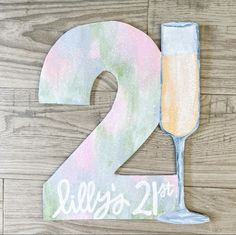 the number two is painted with watercolors and has a glass of champagne in it