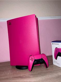 a pink box and two game controllers on a table