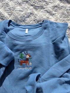 Merry & Bright Organic Cotton Crewneck Embroidered on 100% Organic Cotton  Wintery Christmas Sweatshirt featuring Reindeer | Retro Design & Feel | 100% organic Cotton | Holiday Sweatshirt | Winter Clothes | Sustainable Clothes  Sizes + Fit - Available sizes are S - 2XL - Unisex sizing - I recommend sizing up one size  Material + Feel - Cotton - Crewneck Tee - Embroidered Design - Linen backing for a comfortable feel  Care Instructions - Wash cool with like colors. Turn inside out to protect design. - Tumble dry low or hang to dry for best care. Embroidered Items are stitched to order. Please allow up to 6 days for your order to ship.  * Returns & Exchanges - All sales are final unless the item arrives damaged - If your item arrives damaged, please contact us within 4 weeks of receiving the Christmas Embroidery Shirts, Embroider Crewneck, Clothes Sizes, Merry Bright Christmas, Bright Christmas, Embroidered Crewneck, Holiday Sweatshirt, Shirt Embroidery, Winter Sweatshirt