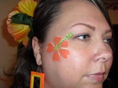 a woman with flowers painted on her face and earring, looking at the camera