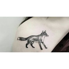 a woman's shoulder with a small fox tattoo on it