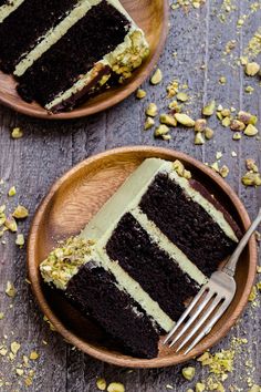 two wooden plates with slices of chocolate cake on them and a fork in the middle