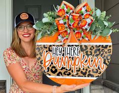 a woman holding up a sign that says hey there pumpkin