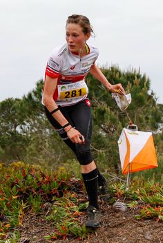 the woman is running with an umbrella in her hand and knee braces on one leg