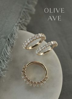 two gold rings sitting on top of a white plate with the words olive ave written above it