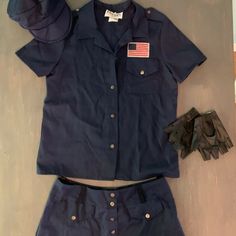 a uniform and gloves are laid out on the floor next to an american flag pin