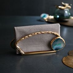 a blue and gold bracelet sitting on top of a table next to a silver napkin