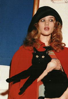 a woman holding a black cat in her arms