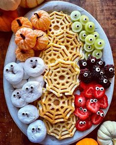 a white plate topped with lots of different types of food next to pumpkins and gourds