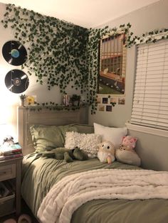 a bedroom with plants growing on the wall above the bed and stuffed animals sitting on the pillow