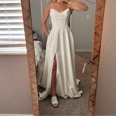 a woman in a white dress taking a selfie