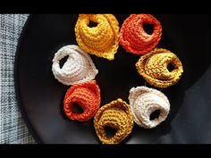 six crocheted rings sitting on top of a black plate