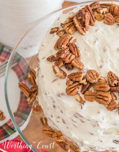 a frosted cake with pecans on top