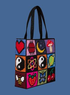 a handbag with many different designs on the front and side, including an apple, mushrooms