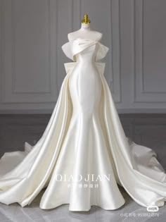 a white wedding dress on display in a room