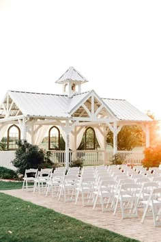 an outdoor wedding venue with white chairs set up for the guests to sit in front of it