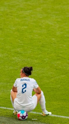 a female soccer player sitting on the ground