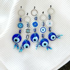 the evil eye keychains are made from glass and have blue beads on them