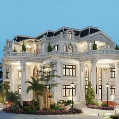 a large white building with lots of windows and lights on it's front porch