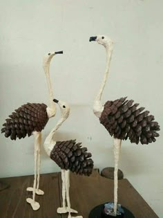 two birds made out of pine cones on a table