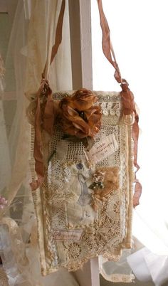 a piece of cloth hanging from the side of a window with lace and flowers on it