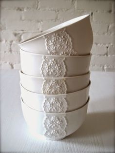 five white dishes stacked on top of each other