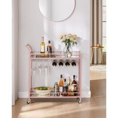 a pink bar cart with bottles and glasses on it