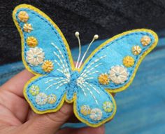 a hand holding a blue and yellow butterfly