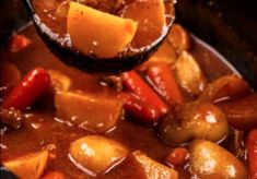 a spoonful of stew with potatoes and carrots in it is being lifted from the slow cooker