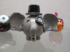 an elephant figurine wearing a top hat with two birds on it's back