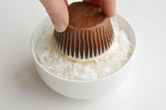 a person is holding a chocolate brush over some rice