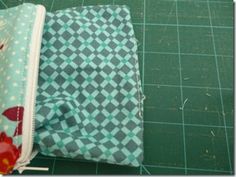 two zippered pouches sitting on top of a cutting board