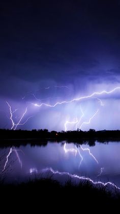 lightning strikes across the sky over a body of water