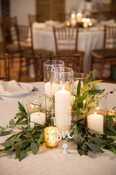 a table with candles and greenery on it