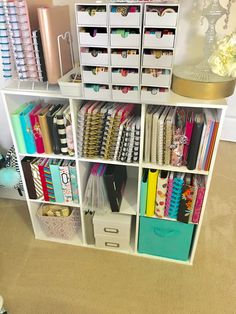 a white shelf filled with lots of crafting supplies and storage bins on top of it