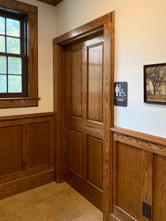 an empty room with wood paneling and two framed pictures on the wall above it