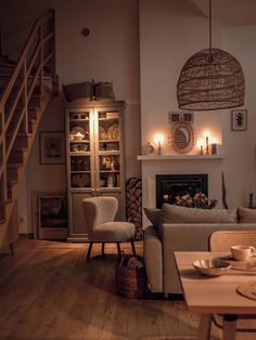 a living room filled with furniture and a fire place under a stair case next to a fireplace