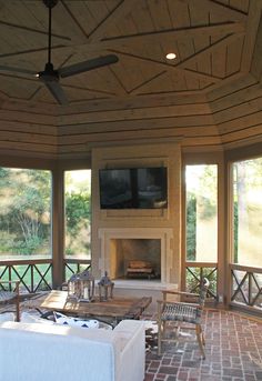 a living room with brick flooring and large windows