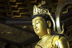 a golden buddha statue sitting inside of a building