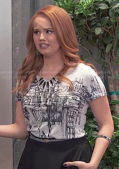 a woman with red hair wearing a white shirt and black skirt