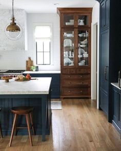 the instagram page shows an image of a kitchen with dark blue cabinets and wood floors