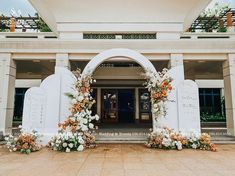 an entrance to a building decorated with flowers and greenery for a wedding or reception