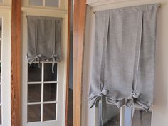 two windows with curtains hanging on them in front of the door and one has a window valance