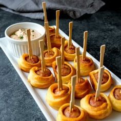 mini pizza bites with spicy dipping sauce on a white platter next to a bowl of dip