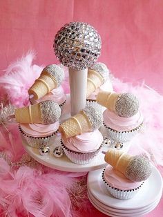 cupcakes with pink frosting and ice cream cones on a cake platter